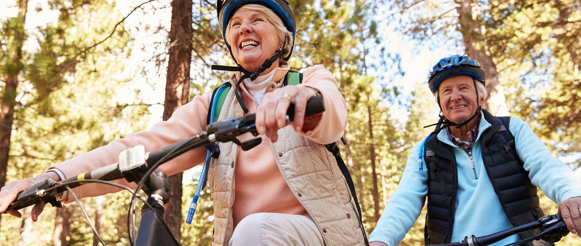 older couple riding bikes in a park